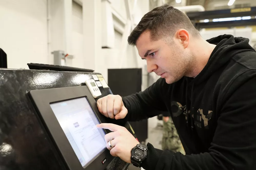 Technician operating a tensile test tower during a mechanical pull test