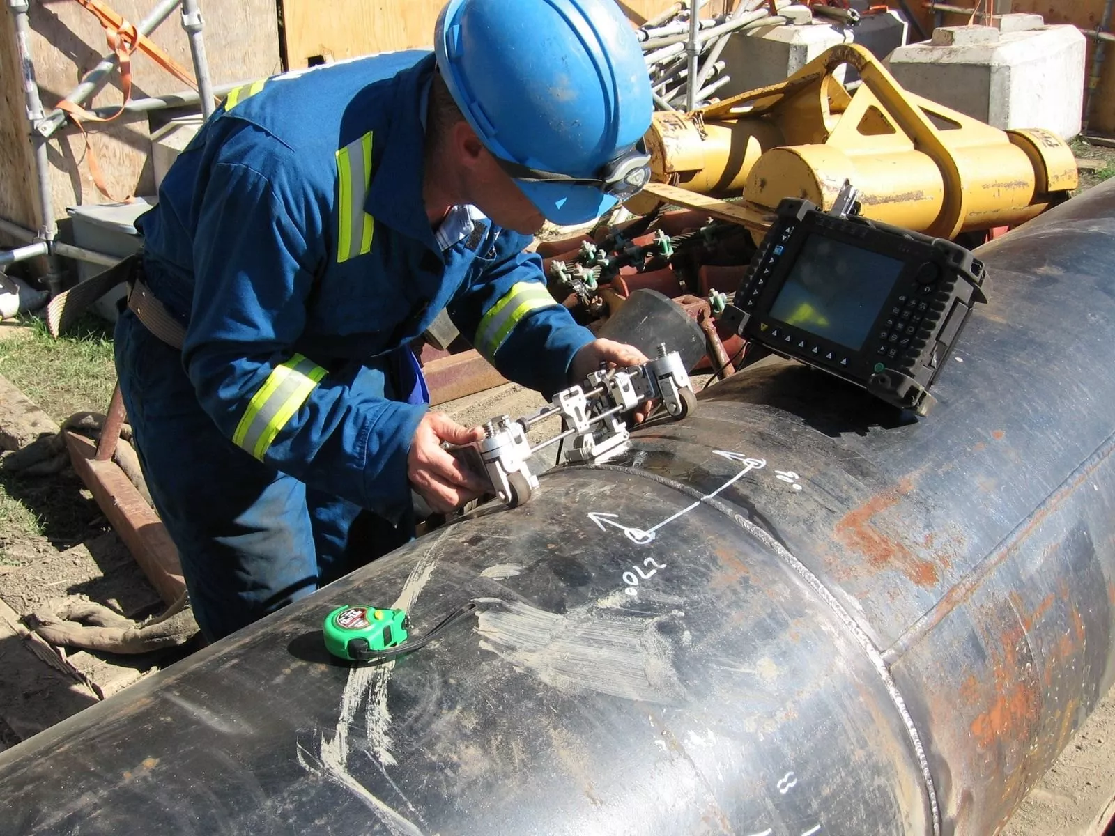 Ultrasonic pipeline weld testing Technician using phased-array ultrasonic testing equipment on a pipeline weld